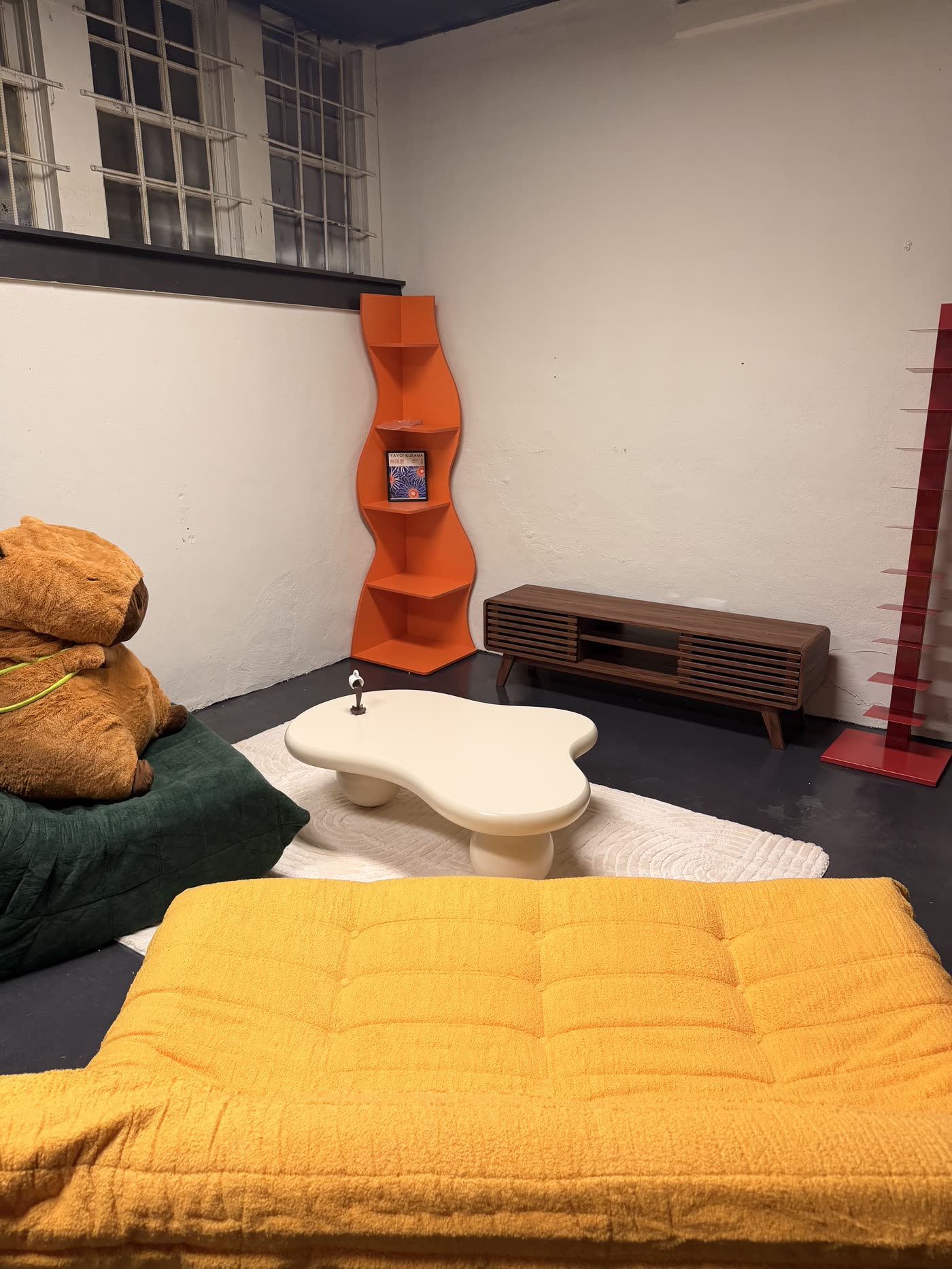 Styled lounge area inside Nine99 with yellow daybed and cloud coffee table
