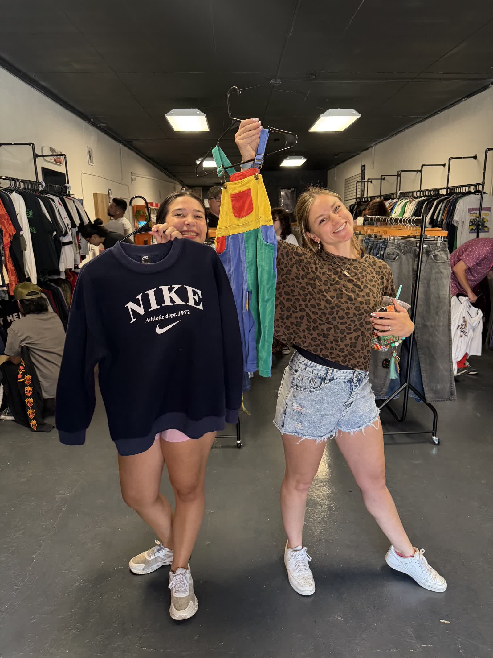 Two happy customers showing off vintage Nike finds at Nine99