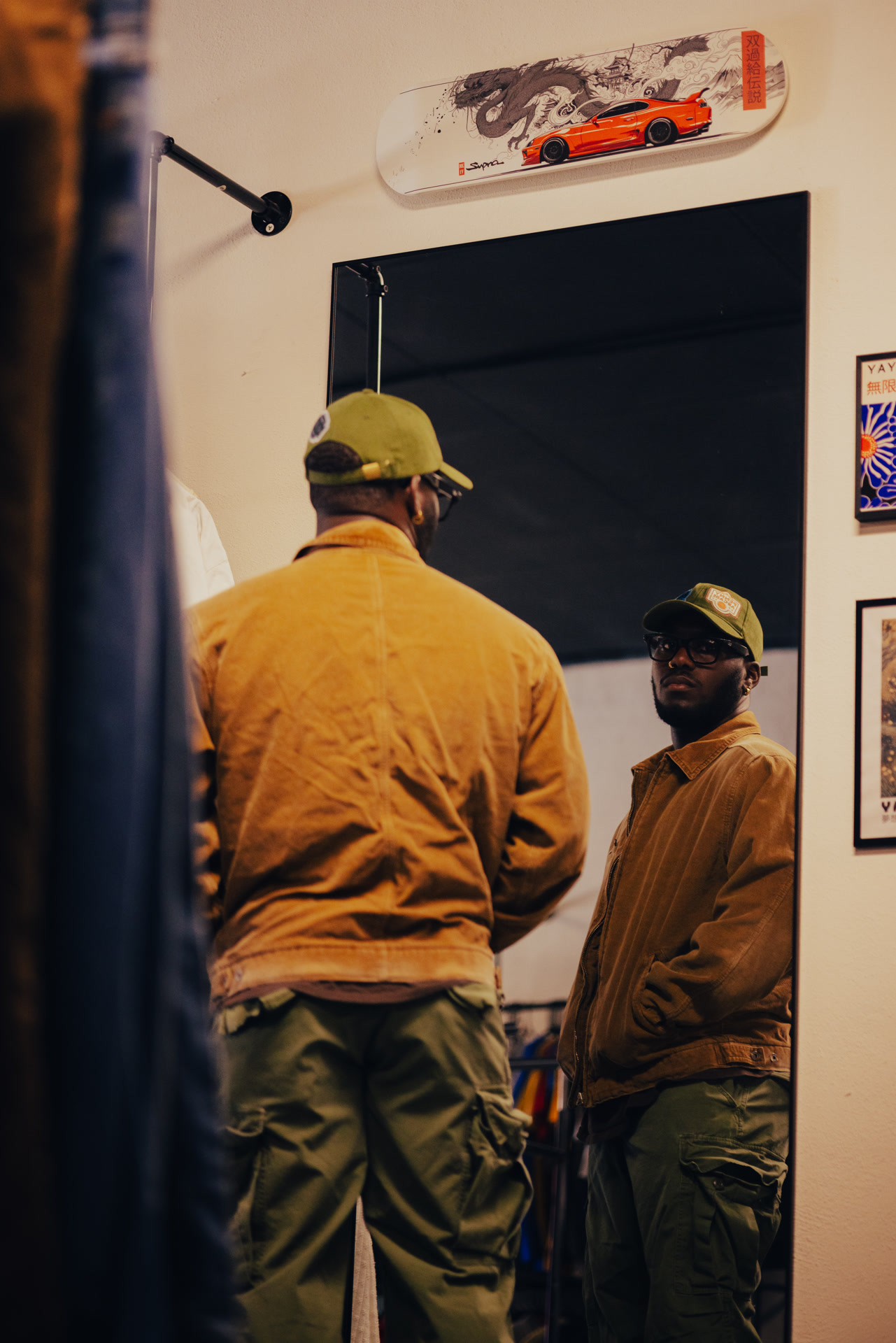 Jaylen checking out a vintage jacket in the fitting room mirror at Nine99