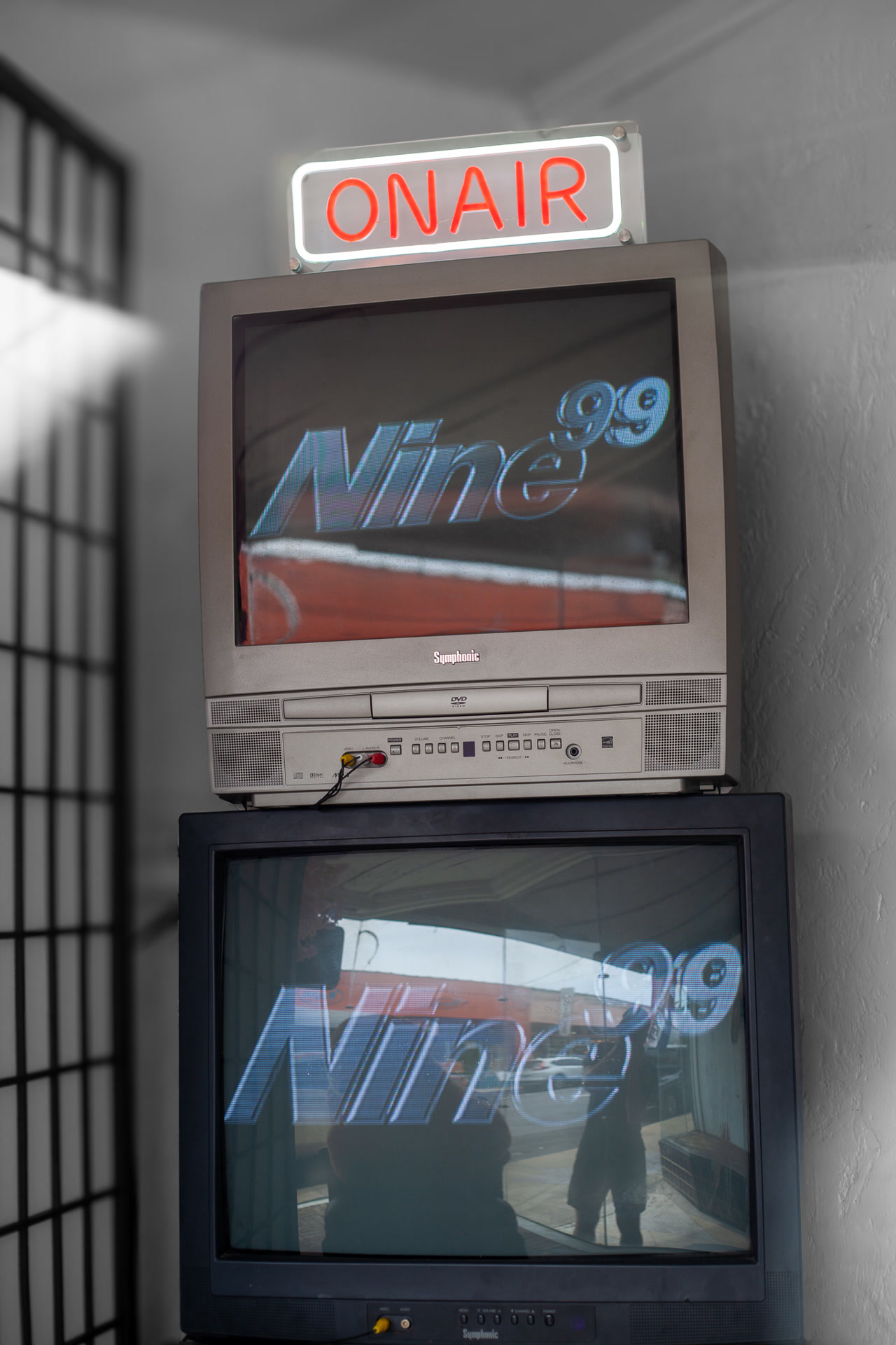Stacked retro CRT TVs displaying the Nine99 logo — store decor