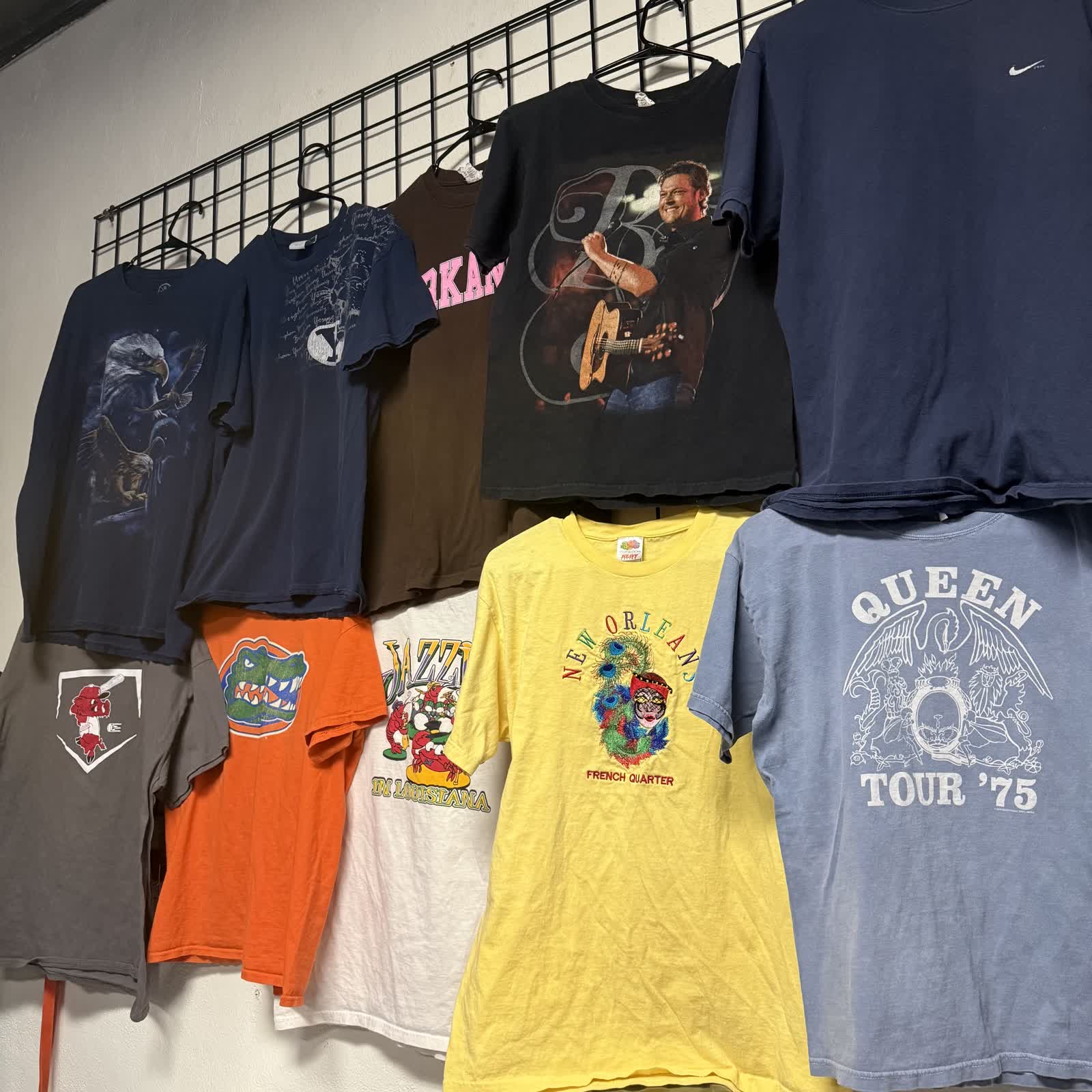 Vintage t-shirts hanging on the wall at Nine99 — Queen, New Orleans, Nike and more